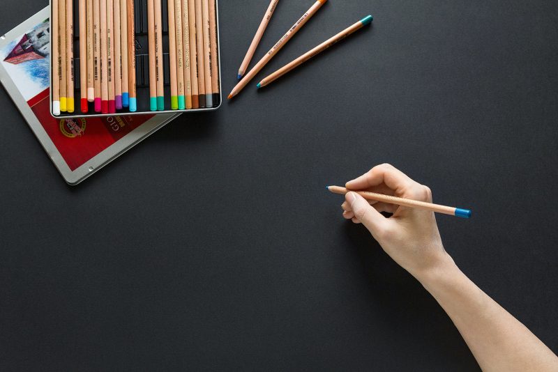 a person drawing on a black surface